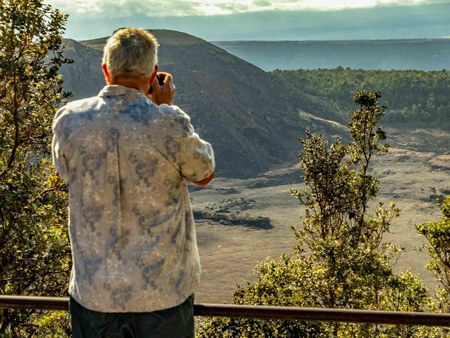 visitor photographs kilauea Iki in volcanoes national park big island hawaii