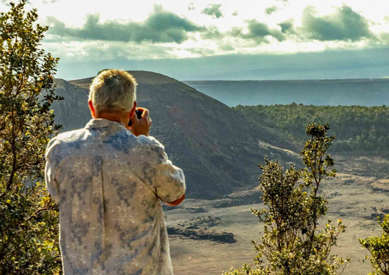 visitor photographs kilauea Iki in volcanoes national park big island hawaii 